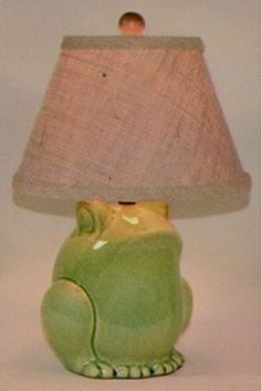 a green ceramic cat lamp with a pink shade