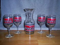 four wine glasses and a decanter on a table