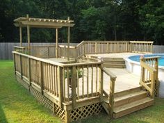 a wooden deck next to a pool with steps leading up to it and a pergolated gazebo