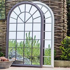 a large arched window sitting next to a potted plant