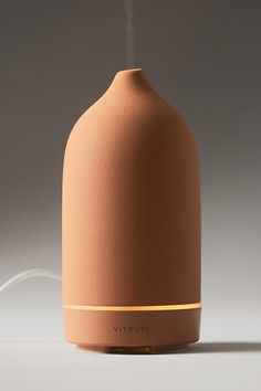 This diffuser uses ultrasonic technology to keep essential oils at their full integrity as they diffuse into the air. Whether placed on a nightstand or a living room shelf, its sleek design elevates any interior. | Stone Terracotta Diffuser by Vitruvi in Brown, Plastic at Anthropologie Oil Diffuser Aesthetic, Diffuser Decor Ideas, Cute Diffusers, Aesthetic Diffuser, Diffuser Aesthetic, Glass Oil Diffuser, Vitruvi Diffuser, Terracotta Diffuser, Luxury Diffuser