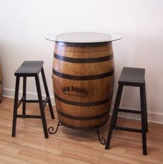 two stools are next to a wooden barrel