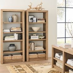 two wooden bookshelves with baskets and vases on them