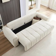 a white couch sitting on top of a hard wood floor