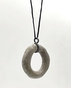 This concrete  pendant long Necklace is a unique and stunning piece of handmade jewelry that combines modern and artistic style The pendant's shape  is irregular round and open made of  concrete. Τhe pendant is passed on a black synthetic cord,with a handcrafted oxidized silver hook clasp.  A unique and elegant accessory perfect for both casual and formal occasions. In contact with skin, moisture and air, concrete becomes darker. Αs each piece is individually handmade, slight variations in  text Cement Jewelry, Concrete Necklace, Concrete Pendant, Concrete Jewelry, Artistic Style, Hook Clasp, Elegant Accessories, Oxidized Silver, Oxidized Sterling Silver