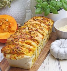 a loaf of bread sitting on top of a wooden cutting board next to some vegetables