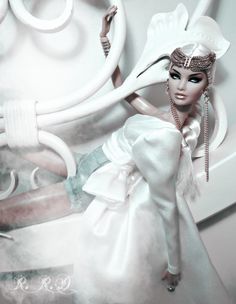 a barbie doll dressed in white and holding a hair comb