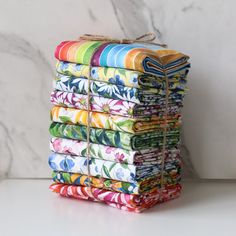 a stack of multicolored cloths sitting on top of each other in front of a marble wall