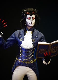 a man dressed in costume and holding an open book with his hands out to the side