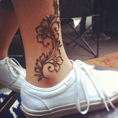 a woman's foot with a flower tattoo on it