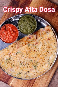 a plate with some food on it and sauces next to it that says crispy ata dosa