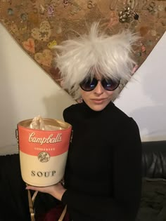 a woman with white hair and sunglasses holding a soup can