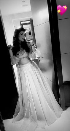 a woman in a long white dress is taking a selfie