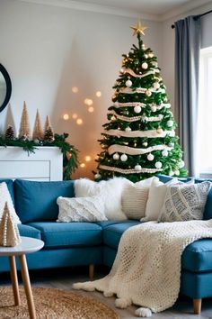 a living room with a blue couch and a christmas tree in the corner on the wall