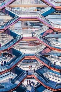 the escalators and platforms in an indoor shopping mall are made of metal, glass and wood