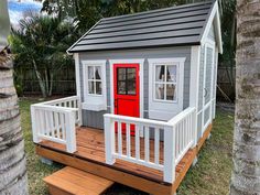 a small house with a red door on the porch