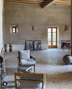 a living room filled with lots of furniture and pictures on the wall next to windows