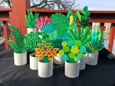 some plants are sitting in white pots on a table