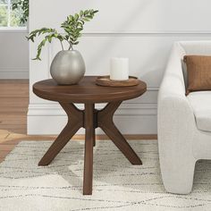 a living room scene with focus on the coffee table and chair, which has a plant in it