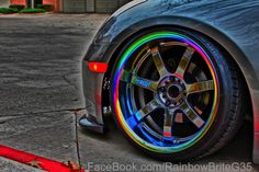 a car parked on the street with its wheels painted multicolored