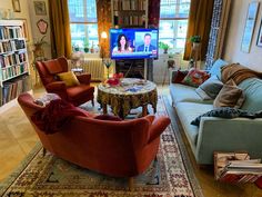 a living room filled with furniture and a flat screen tv mounted to the side of a wall