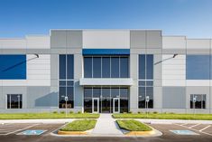 an industrial building with large windows and blue shutters on the front door is shown