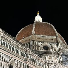 the top of a building with a clock on it's face at night time