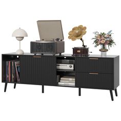 an old record player sitting on top of a black entertainment center with drawers and shelves