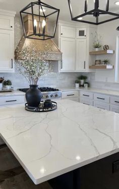 a large kitchen with white cabinets and marble counter tops, an island in the middle