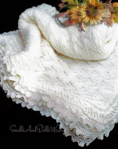 a white crocheted shawl with sunflowers on it