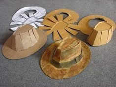 several hats made out of cardboard sitting on the floor