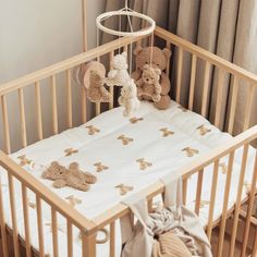 a crib with teddy bears hanging from it's sides