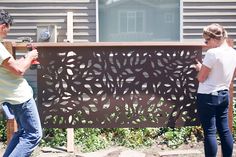 two people are working on an outdoor screen