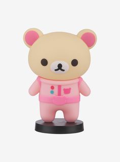 a small toy bear wearing a pink outfit