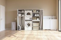 a room with a washer, dryer and cabinets on the floor in it