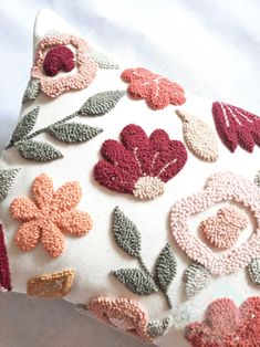 a decorative pillow with crocheted flowers on it