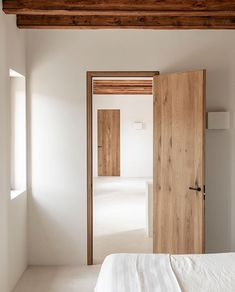 an empty bedroom with white walls and wooden doors