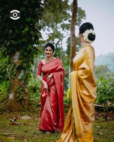 a woman in a red sari standing next to another woman