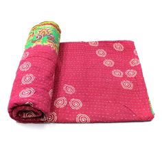 a rolled up pink blanket sitting on top of a white floor next to a roll of fabric