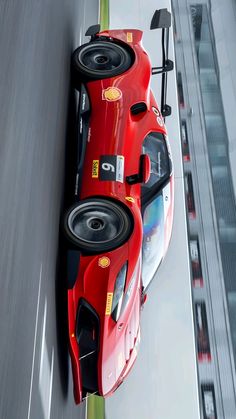 two red race cars driving down a track with speakers on the front and rear wheels