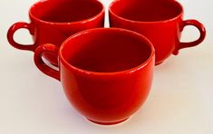 three red coffee cups sitting next to each other