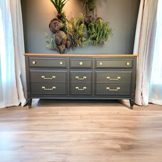 the dresser is painted gray with gold handles