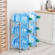 there is a metal rack with six water bottles on it next to a measuring ruler