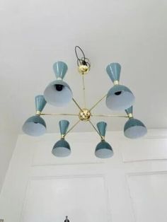 a blue chandelier hanging from the ceiling in a room with white walls and doors