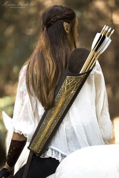 a woman with long hair holding two arrows