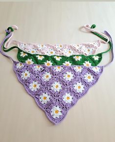 three crocheted bikinis with flowers on them are laying on a table top