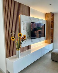 a vase with sunflowers in it sitting on a white entertainment center that is built into the wall