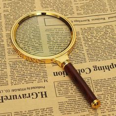 a magnifying glass sitting on top of a newspaper with words written in russian