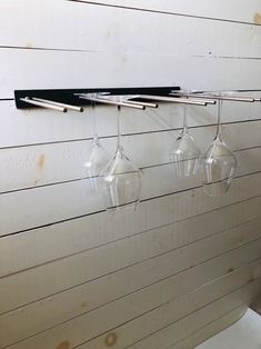 three wine glasses hanging from a wall