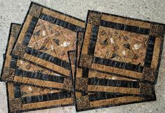 four quilted placemats sitting on top of a floor next to each other